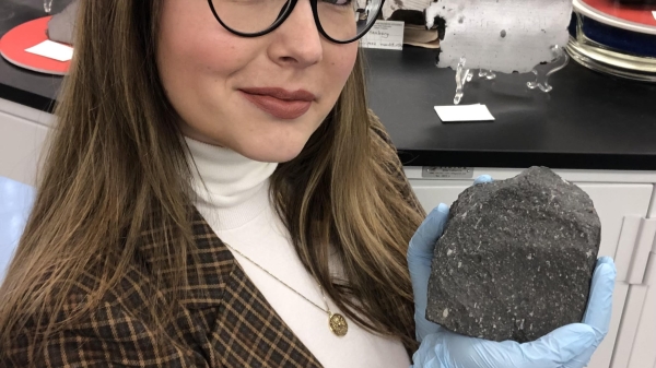 Jemma Davidson holding a carbonaceous chondrite.