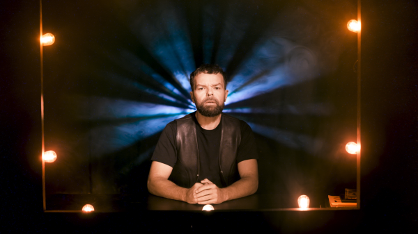 Portrait of poet Lemon Andersen surrounding by stage lights.