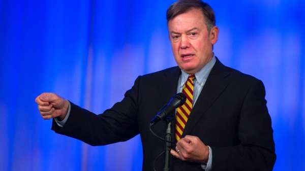 Man standing in front of a blue background.