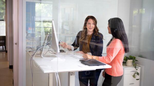 Young business professionals talking at standing desk