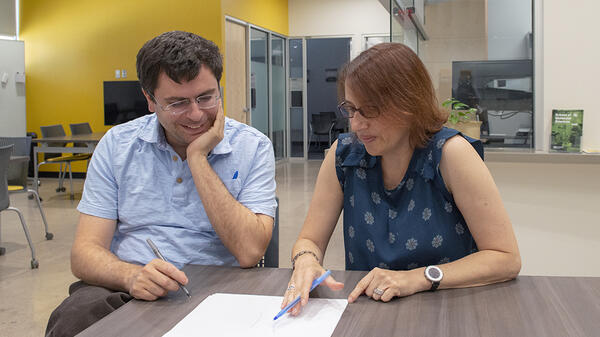 man and woman sitting at a table looking at a paper