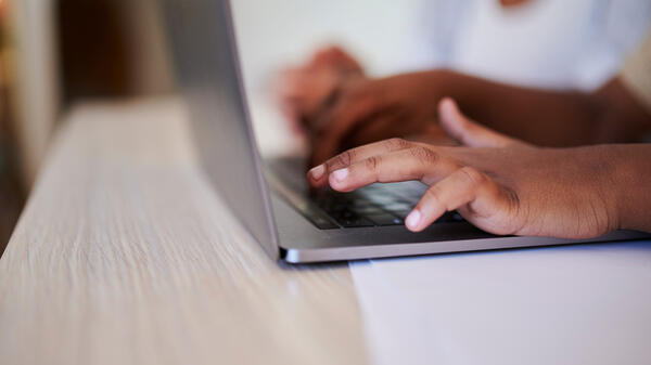 Hands tpying on a laptop.