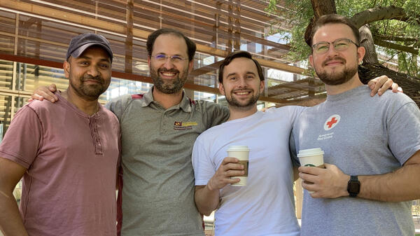 Amm Hasib, Bruno Azeredo, Aliaksandr "Sasha" Sharstniou and Stanislau "Stas" Niauzorau smiling with arms around one another.