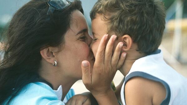 Mother kissing child