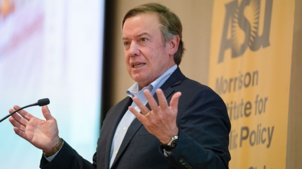 ASU President Michael Crow speaking into a microphone at an event.