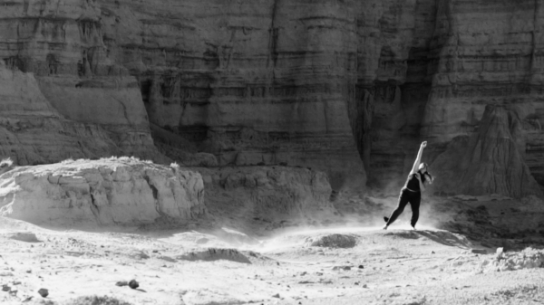 A dancer performs in a desert landscape