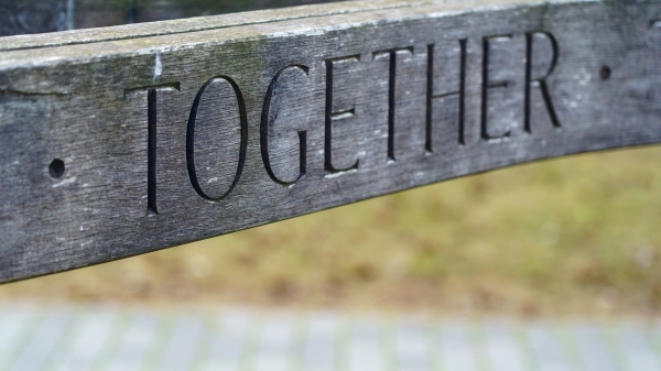 Close-up photo of a piece of wood that reads "Together."