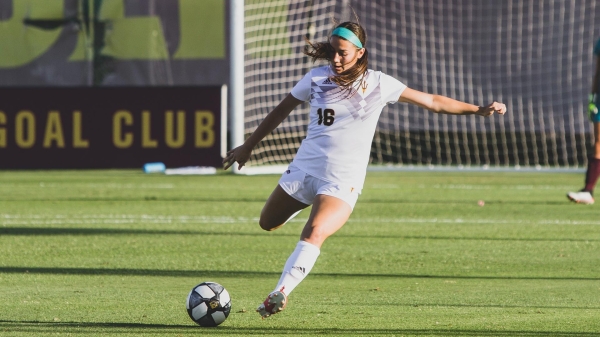 ASU student Nicole Soto winding up to kick a soccer ball on a field.