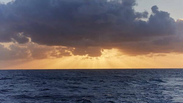 sunset with clouds over ocean waters