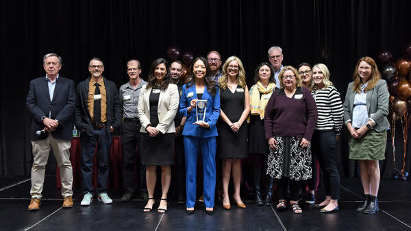 People standing onstage holding an award.