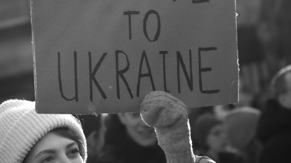 Woman holding sign that says Peace to Ukraine