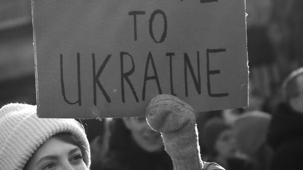 Woman holding sign that says Peace to Ukraine