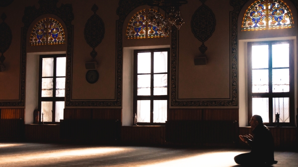 A person prays in a mosque.