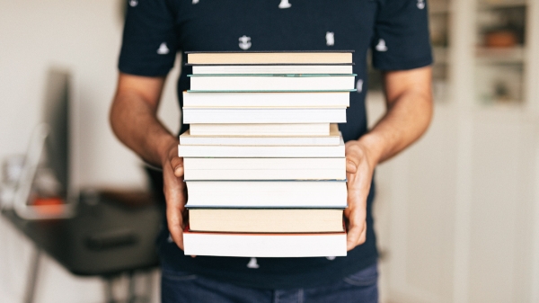 Man carrying stack of books