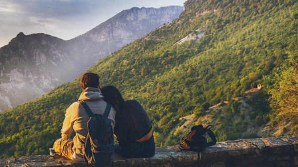 couple sitting next to each other looking at mountain view