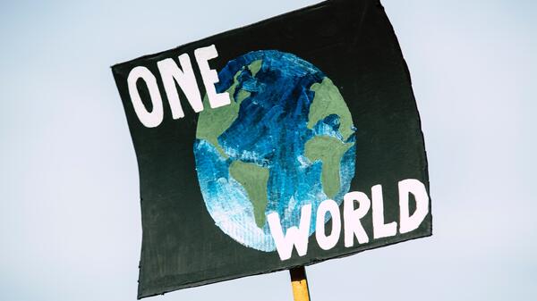 Poster with a drawing of Earth on it that reads: "One World."