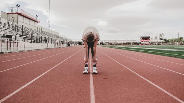 High school student stretching before a track meet.