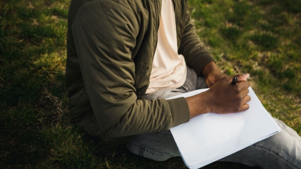 Man sitting and writing on paper