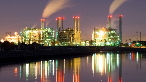 Lights of a power plant are reflected in a lake at night.