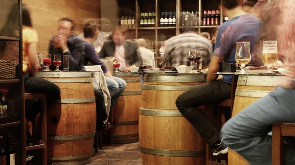 restaurant where people are sitting around at tables shaped like barrels