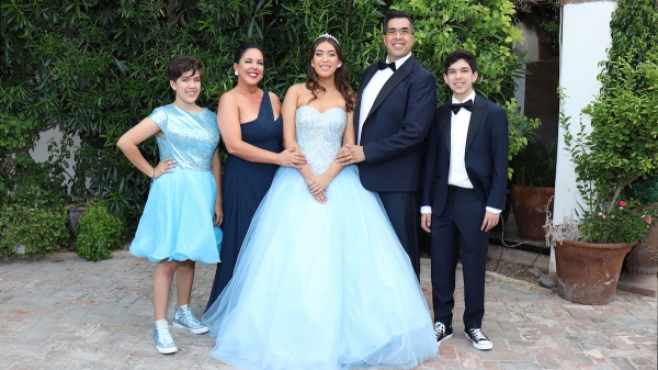 Family of five standing dressed in formal clothing