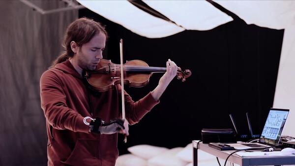 Instructor and violinist Seth Thorn holding his hybrid violin 