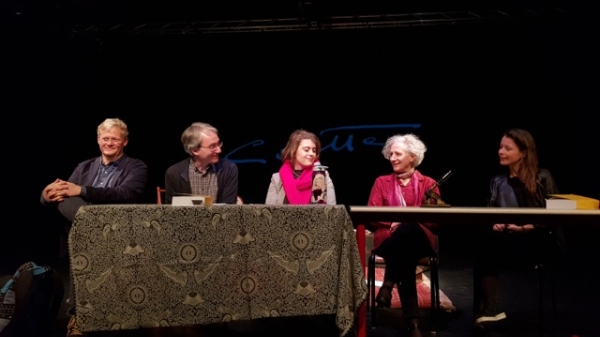 ASU alumna Shannon Ditto speaks on a panel at the University of Strasbourg. Ditto is in the center wearing a neon pink scarf. Two other panel members are on either side of her. They are all seated at a long table.