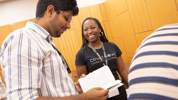 Man holding papers and woman smiling at him.