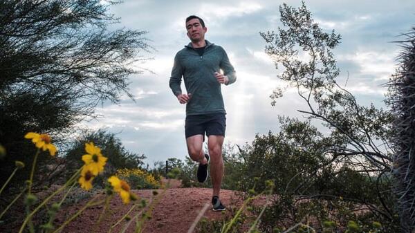 College of Health Solutions graduate Darrel Wang jogging on an outdoor trail.