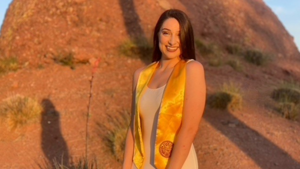 Edson College Outstanding Graduate Kaitlyn Weeks poses for graduation pictures wearing a gold graduation stole