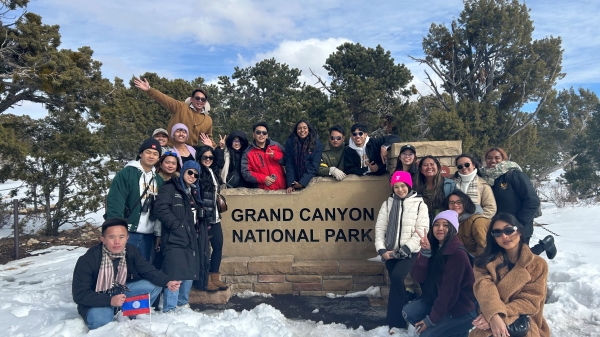YSAELI fellows posting near sign for the Grand Canyon National Park, surrounded by snow and trees.