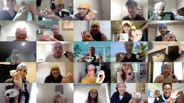 A screenshot shows 25 small images of workshop participants, taken over Zoom. Each person is holding up onigiri, a Japanese rice ball, that has been shaped to look like a panda.