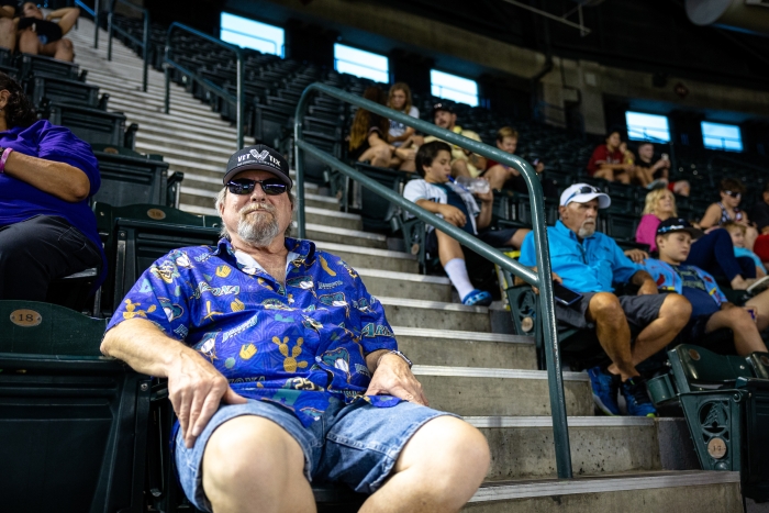 Man wearing purple Diamondbacks shirt at baseball stadium
