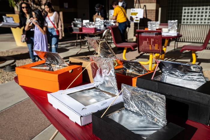 Solar ovens made from shoeboxes laid outside on tables
