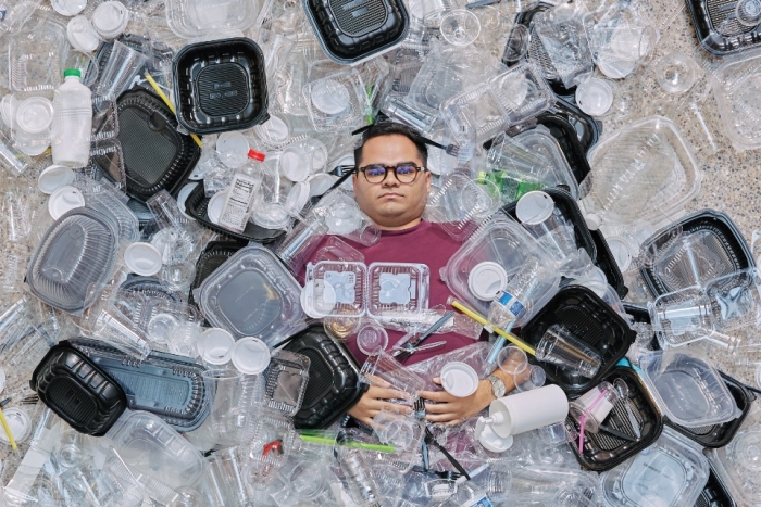 Man lying down with plastic containers covering him