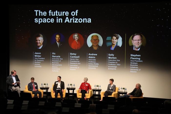 Panel of 5 experts on stage at the 2023 Arizona Space Summit. The screen behind says "The future of space in Arizona."