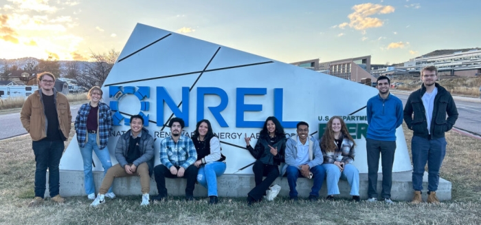 Group of students stand in front of NREL sign