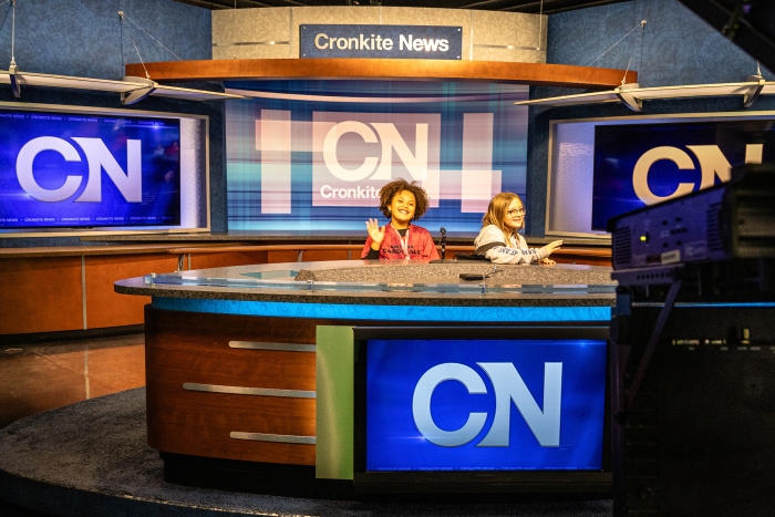 Kids sit at the Cronkite News anchor desk