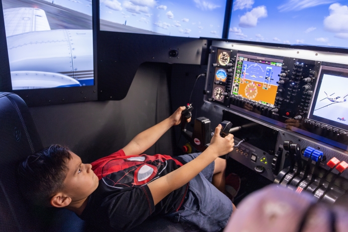 Young boy using a flight simulator.