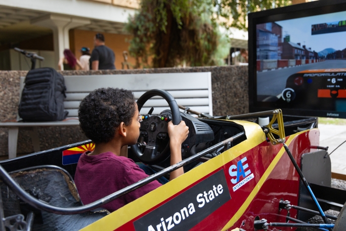Young boy virtually driving a small race car