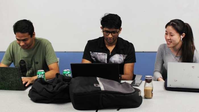 Three students work on laptops