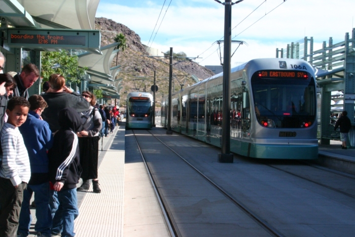 A crowd stands at a stop for the Valley Metro Rail, the Phoenix light rail system.