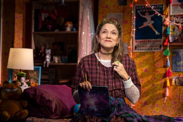 Woman portraying young girl sitting in teenage bedroom in Broadway production