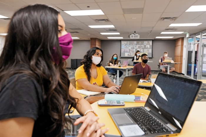 Students on laptops in classroom wearing masks