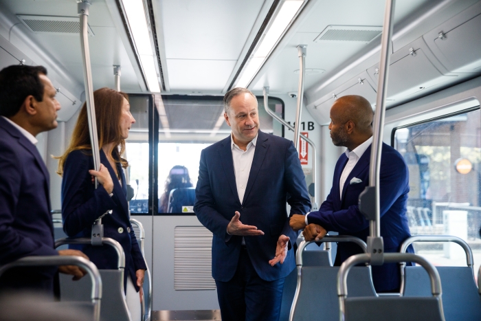 Group of government officials speaking while riding a streetcar.