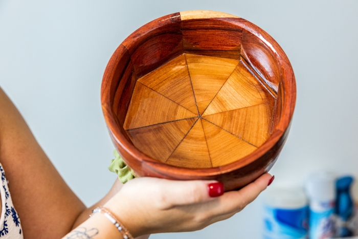 Person holding a hand-carved wooden bowl