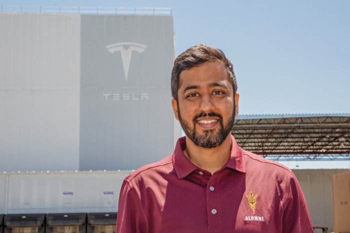 Portrait of a man wearing a maroon, button-down Sun Devil shirt in front of a Tesla building