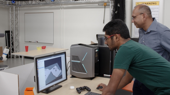 Srivastava and a student observe the images collected by the robot on a monitor.