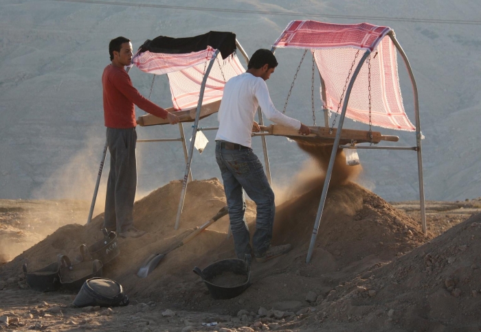 Team members Riad and Fadi al-Garaleh screen the excavated dirt from al-Khayran for artifacts.