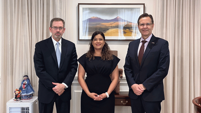 Two men and a woman pose for a photo